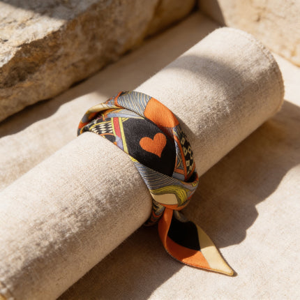 Bracelet en soie étroite 2 cm de large, motif Dame de Cœur orange, noir et jaune, par horizons boutique. Peut se nouer au poignet ou sur un sac.