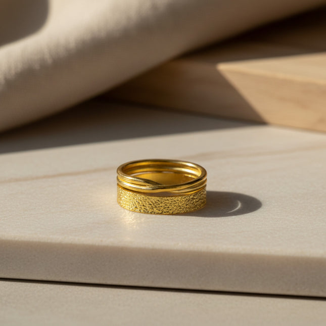 Bague empilable en or 24 carats de la marque Horizons Boutique, composée d'une bande texturée et de deux fils entrelacés. Taille réglable.