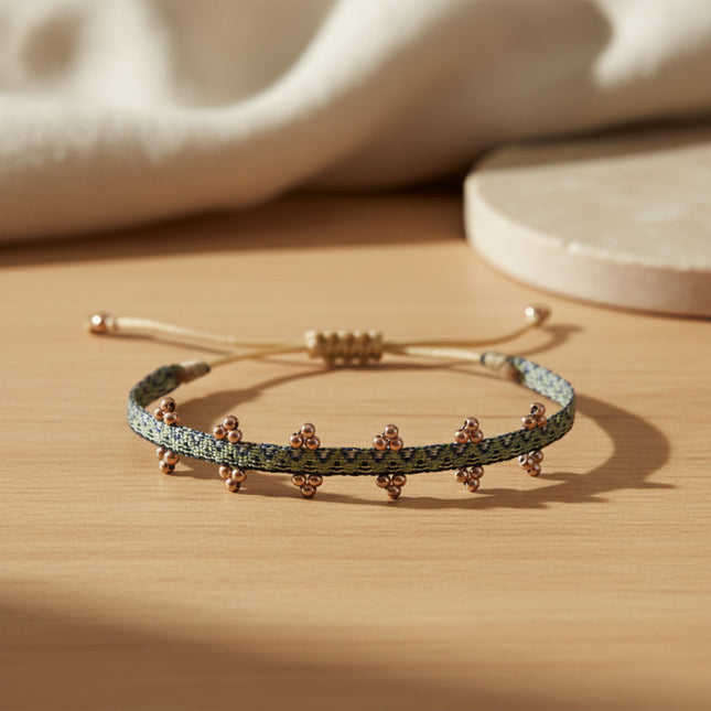 Bracelet fin tissé main horizons boutique en tons argent et or rose, orné de petites billes, ajustable par cordon ciré.