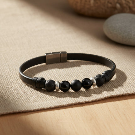 Bracelet TRÉCHIC Single Noir en cuir noir avec fermoir magnétique en acier, orné de perles d'onyx, de lave et de métal argenté.