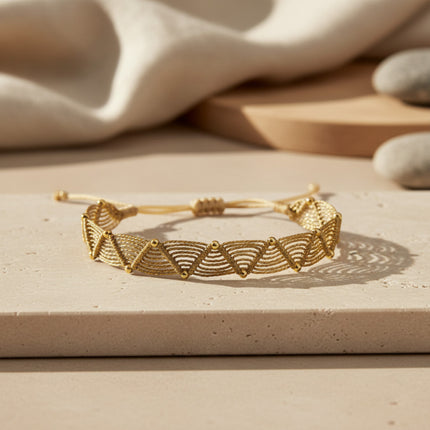 Bracelet LeJu en fil de polyester doré, tissé main avec motif zigzag et billes dorées, ajustable.