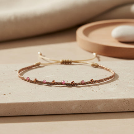 Bracelet fin LeJu en or rose avec tourmalines roses et perles dorées, tissé main, ajustable.