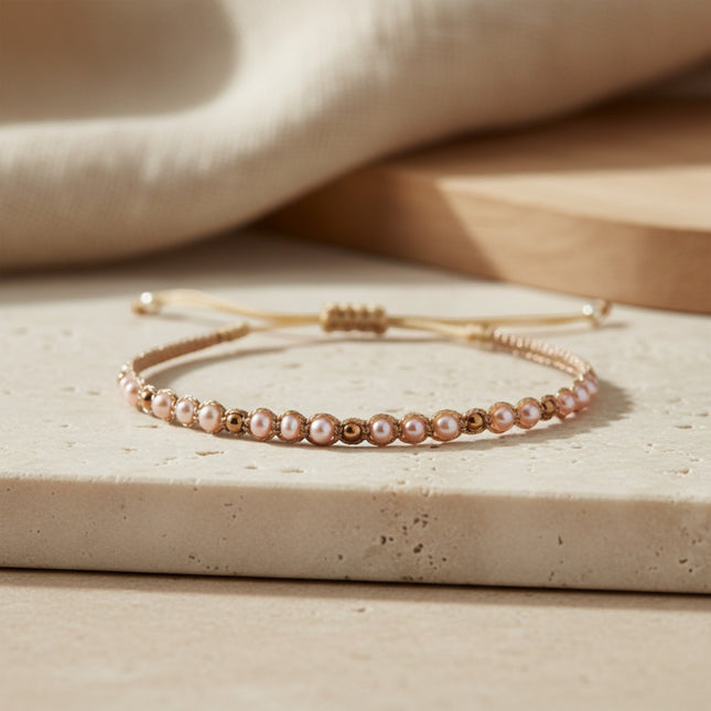 Bracelet fin doré LeJu Holly en perles d'eau douce roses et billes dorées, tissé main, taille ajustable.