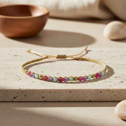 Bracelet fin doré LeJu Holly tissé main avec perles d'eau douce et pierres semi-précieuses roses, violettes et turquoise.