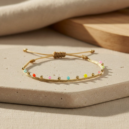 Bracelet ajustable LeJu en or, tissé main avec perles de verre japonaises multicolores et billes en or.