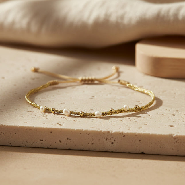 Bracelet fin LeJu en or jaune, tissé main, orné de perles d'eau douce et de billes dorées, ajustable.