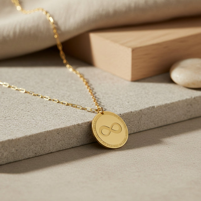 Collier horizons boutique en laiton plaqué or, médaille ronde gravée symbole infini, inscription tour de pourtour.