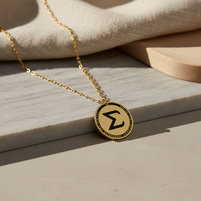 Collier horizons boutique en laiton plaqué or, médaille ronde gravée de la lettre Sigma et d'une inscription.